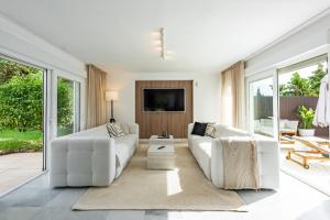 a living room with white furniture and large windows at Cozy Villa With Pool In Marbella Nueva Andalucia in Marbella