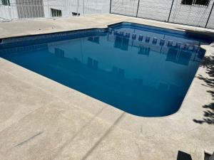 a swimming pool with blue water in a building at Departamento en Acapulco Caleta in Acapulco
