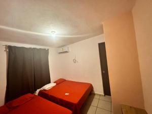 a small room with two beds and a window at Departamento en Acapulco Caleta in Acapulco