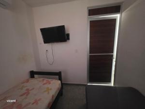 a bedroom with a bed and a television on the wall at Nómadas in San Luis