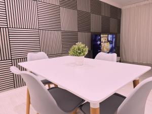 a white table and chairs in a room with a wall at Wildoaks in Northwood