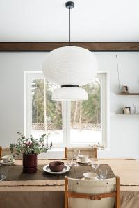 a dining room with a table with a white chandelier at Charming Seaside Country Cottage in Myza Lakhetaguze +18 photos