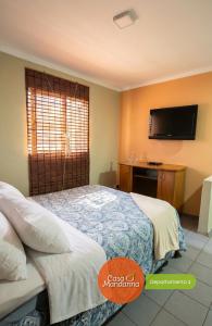 a bedroom with a bed and a tv on the wall at Casa Mandarina San Luis in La Punta