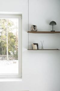 a white room with a window and a shelf at Charming Seaside Country Cottage in Myza Lakhetaguze