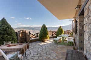 an outdoor patio with a view of the mountains at Petrino Lodge Stone Mountain Retreat in Kato Trikala Korinthias