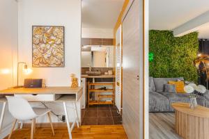 a living room with a desk and a couch at Jungle Saintaise - Appartement, Hypercentre, Fibre, Tv 4K, Parking Privé Payant in Saintes