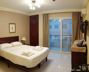 ein Schlafzimmer mit einem großen Bett und einem großen Fenster in der Unterkunft Saint John Hotel in Madaba