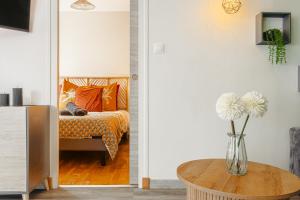 a living room with a vase of flowers on a table at Jungle Saintaise - Appartement, Hypercentre, Fibre, Tv 4K, Parking Privé Payant in Saintes
