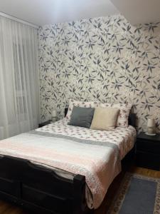 a bedroom with a bed with a floral wallpaper at Mira in Čajetina