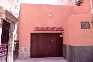 a red building with a large door on it at Riad Asma in Taroudant