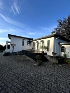 a white house with a brick driveway in front of it at Sweet Home in Aarhus