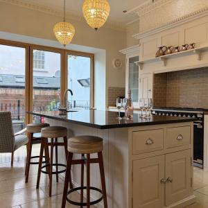 a kitchen with a large island with bar stools at Luxury Georgian Townhouse Tenby Sleeps 8 Parking Permit in Tenby
