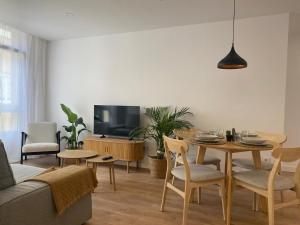 a living room with a table and a tv at A Ribeira - BoaOnda in Cee