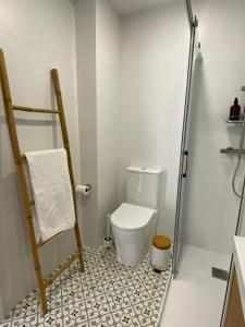 a small bathroom with a toilet and a shower at A Ribeira - BoaOnda in Cee +5 photos