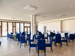 a dining room with blue chairs and tables at DM Hoteles Nasca in Nazca