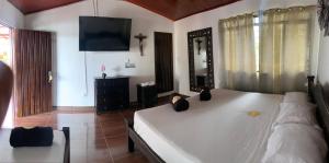 a bedroom with a large white bed with a mirror at Finca Hotel San Sebastian in La Paloma