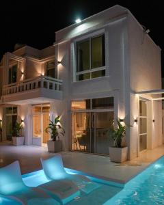 a villa with a swimming pool at night at Natalie Aqua villa heated pool 3BD DeadSea in Al Kafrayn