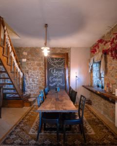 a dining room with a table and chairs and a chalkboard at Petrino Lodge Stone Mountain Retreat in Kato Trikala Korinthias