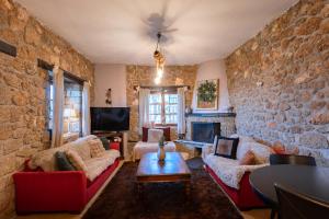 a living room with a stone wall at Petrino Lodge Stone Mountain Retreat in Kato Trikala Korinthias