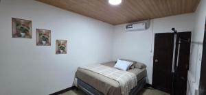 a bedroom with a bed and two pictures on the wall at Casa Petunia, Managua in Managua
