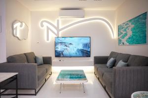 a living room with two couches and a table at Natalie Aqua villa heated pool 3BD DeadSea in Al Kafrayn