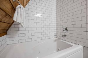 a white bath tub in a white tiled bathroom at Snowball House in Government Camp +30 photos