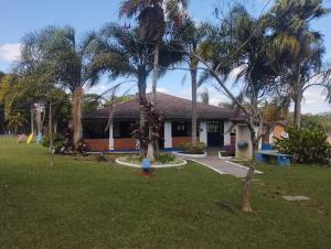 a house with palm trees in front of a yard at Spin world Clube São Roque in São Roque