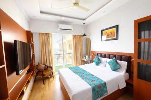 a hotel room with a bed and a television at Sunhaven Studio I Work & Leisure Stays I Near Expo Mart in Greater Noida
