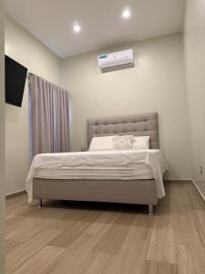 a bedroom with a bed and a air conditioner at Villa Vazquez in Capiatá