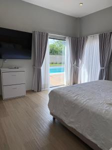 a bedroom with a large bed and a large window at Villa Vazquez in Capiatá