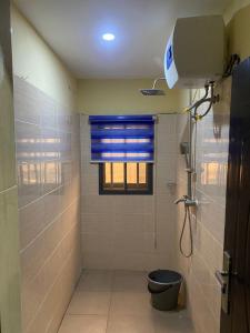 a bathroom with a shower and a toilet and a window at Caligeo Suites I in Ibadan +20 photos
