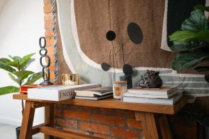 a table with books on top of a brick wall at Premium Design Loft - Old Town in Košice +15 photos