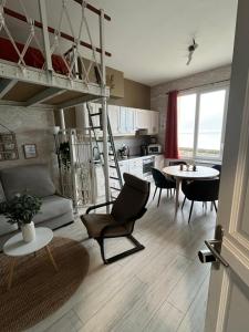 a living room with a loft bed and a kitchen at L'horizon d'Ault, prêt à séjourner, draps & serviettes inclus, lits faits à l'arrivée in Ault