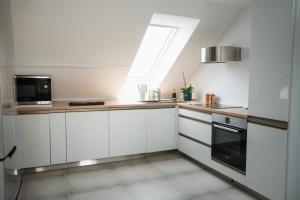 a kitchen with white cabinets and a window at Premium Design Loft - Old Town in Košice
