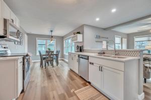 a kitchen with white cabinets and a dining room at Okoboji BLUEtiful Cottage in Arnolds Park