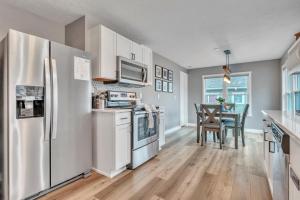 a kitchen with stainless steel appliances and a table at Okoboji BLUEtiful Cottage in Arnolds Park +21 photos