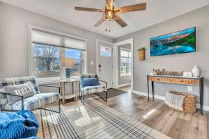a living room with a ceiling fan and a fireplace at Okoboji BLUEtiful Cottage in Arnolds Park