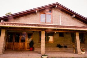 a brick house with wooden doors and windows at Loft 73 in Bento Gonçalves