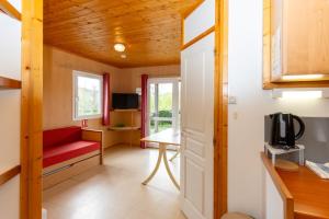 a small room with a red bench and a tv at Camping l'Estela sur le GR70 in Le Monastier sur Gazeille