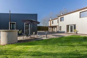 a patio with a table and chairs and an umbrella at Suite Home Ferrara in Ferrara
