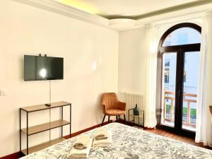 a bedroom with a bed and a tv and a chair at Maison Villa Foch in Meaux