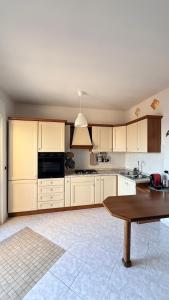 a kitchen with white cabinets and a wooden table at Appartamento “BellaVista” a Norma in Norma