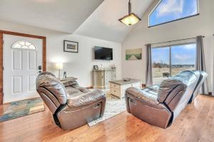 a living room with two leather chairs and a tv at Bridges Bay Vacation Cabin 115 in Arnolds Park