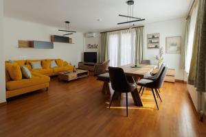 a living room with a table and a yellow couch at Villa Elysia in Porto Rafti