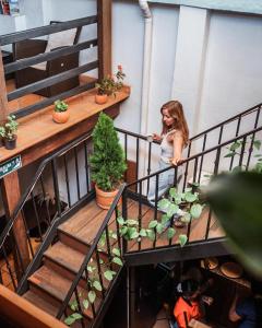 a woman standing on a balcony next to plants at THIS IS COLOMBIA HOSTEL in San Gil