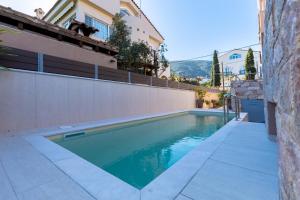 a swimming pool in front of a house at Villa Elysia in Porto Rafti