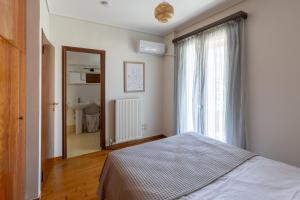 a bedroom with a bed and a window and a sink at Villa Elysia in Porto Rafti +25 photos