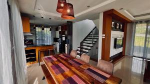 a kitchen and dining room with a wooden table at Staycation at Sandari Batulao Overlooking Spot in Calo