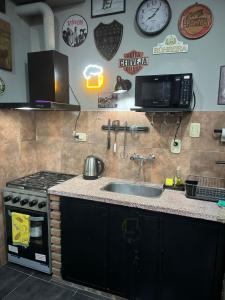 a kitchen with a sink and a stove at Quincho cervecero in San Fernando del Valle de Catamarca