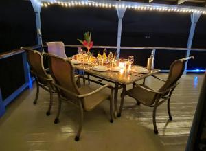 a table with chairs and glasses on a balcony at Mountain Chalet with Awesome Sea View in Loma Partida